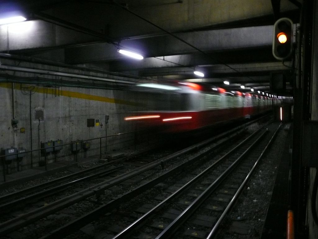 Blurred metro train speeding through an underground tunnel in Milan Metro Line 1.